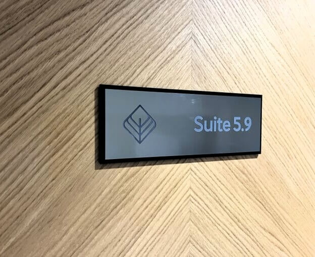 A Suite wayfinding sign on a wall/door for the private office space.